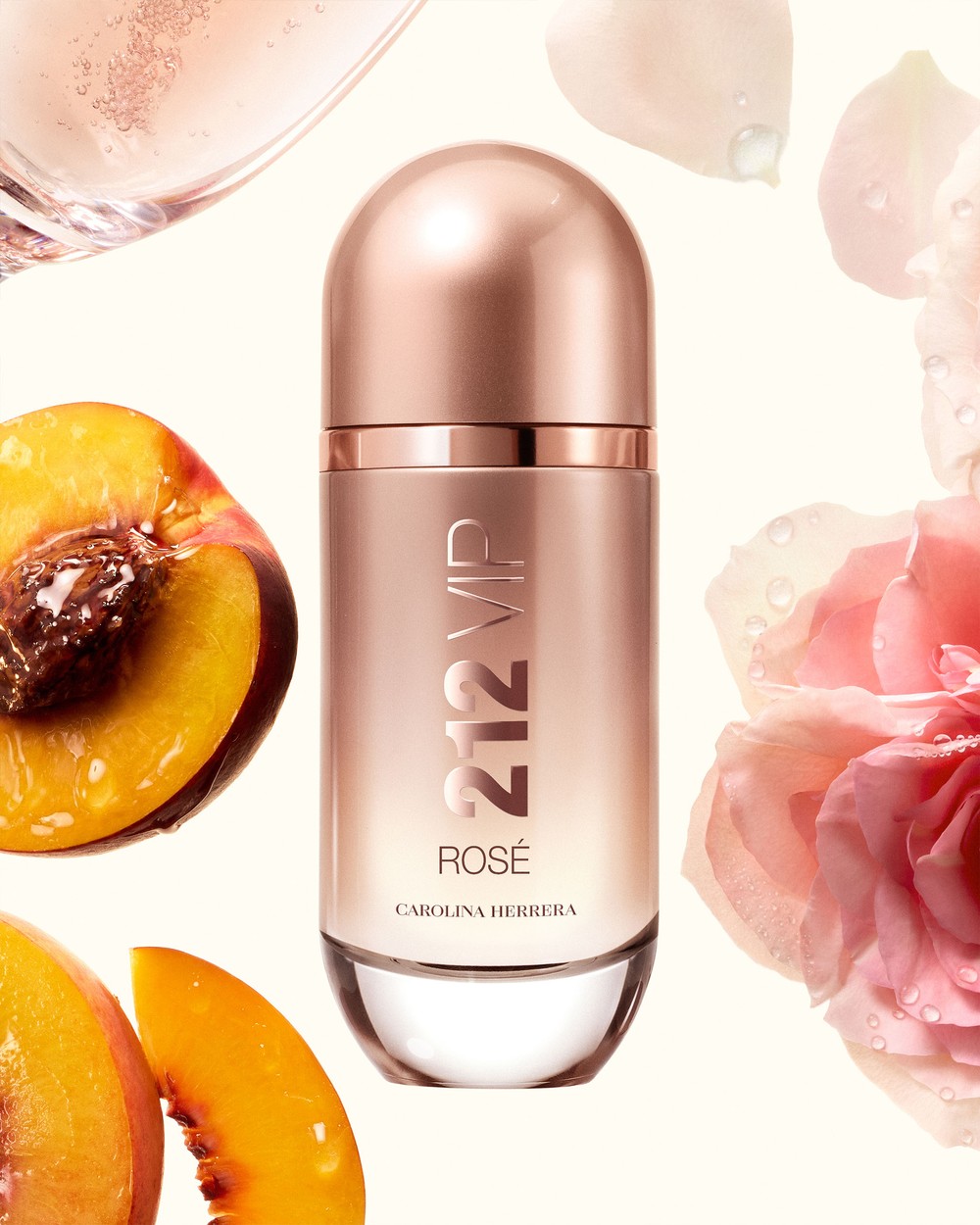 Cena 212 VIP Rosé: frasco rosé com pêssego cortado e rosa, taça de champagne ao fundo