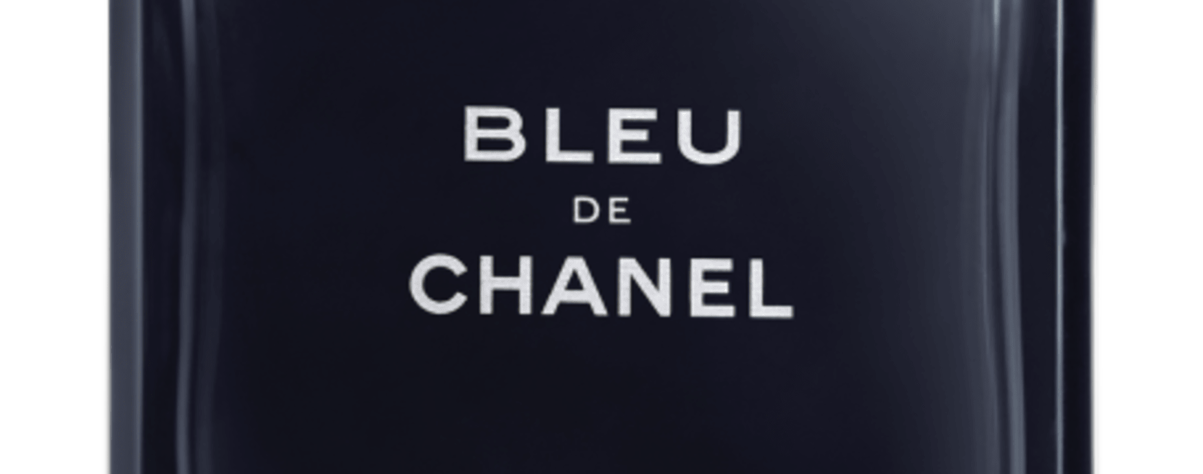 Close-up do lettering Bleu de Chanel serigrafado em prata no centro do frasco azul-marinho fosco