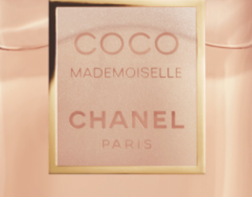Close-up da etiqueta dourada COCO MADEMOISELLE CHANEL PARIS sobre o vidro facetado