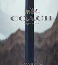 Close-up do COACH OPEN ROAD gravado na faixa azul-marinho sobre o vidro transparente